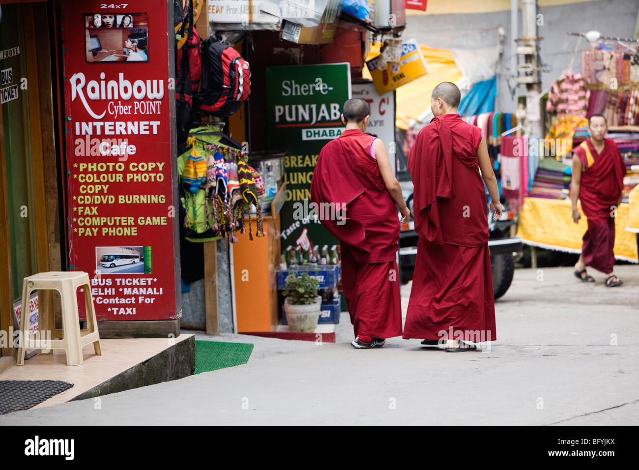 Buddhistische Mönche und Nonnen, vorbei an einem Internet-Café in Dharamsala, Indien. Stockfoto
