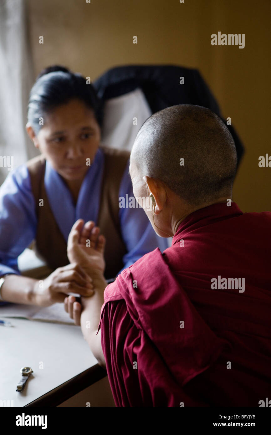 Ein Amchi, traditionellen tibetischen Arzt, macht die Diagnose anhand ihrer Patientin Puls. Dharamsala, Indien. Stockfoto