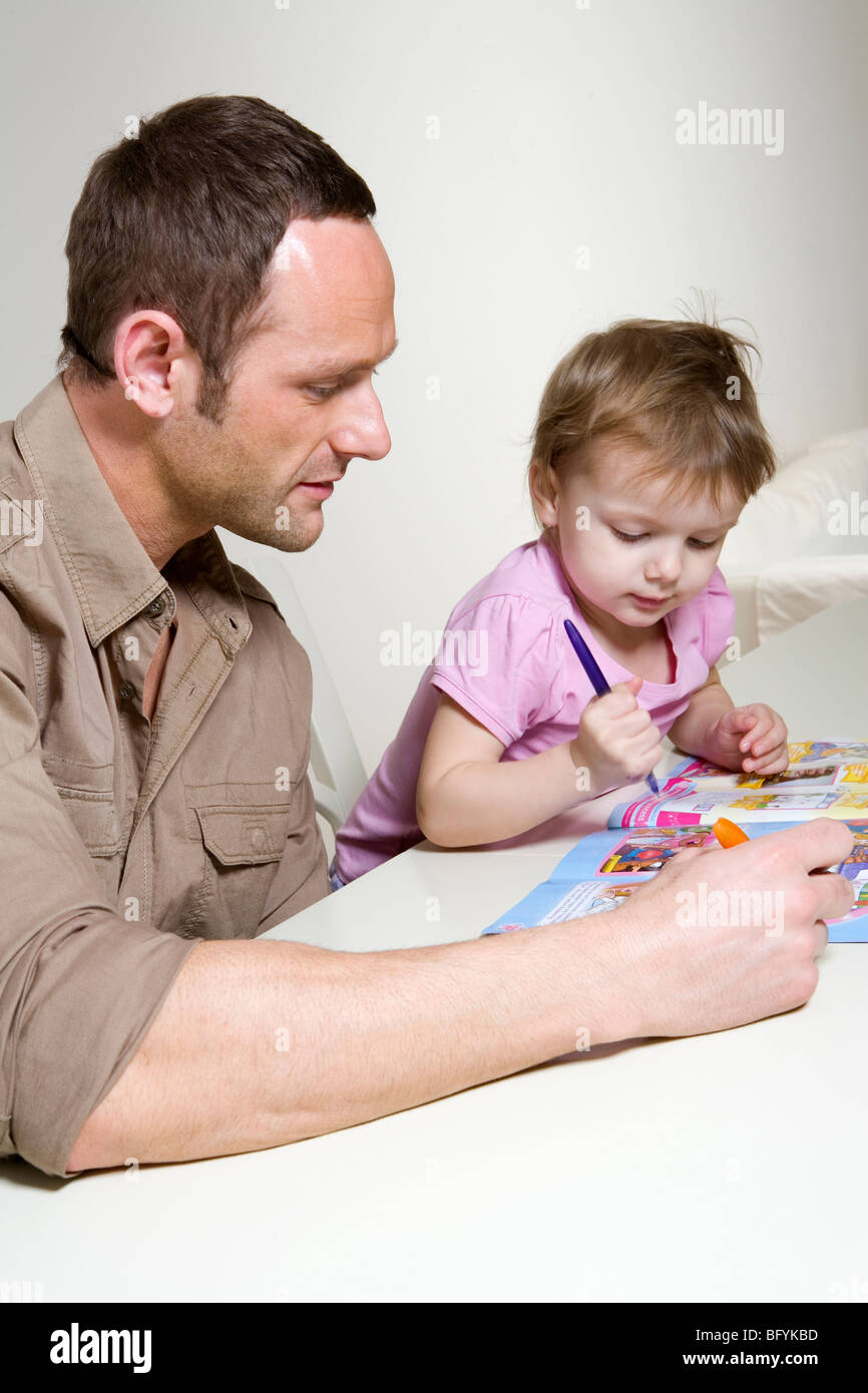 Vater seine junge Tochter zu helfen, mit einem Aufgabenbuch Stockfoto