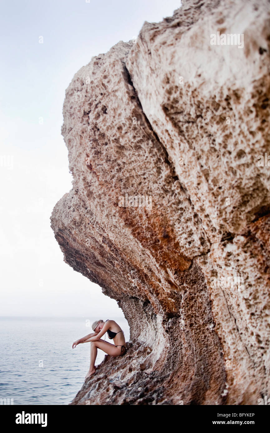 Frau sitzt auf den Felsen am Felsen Stockfoto