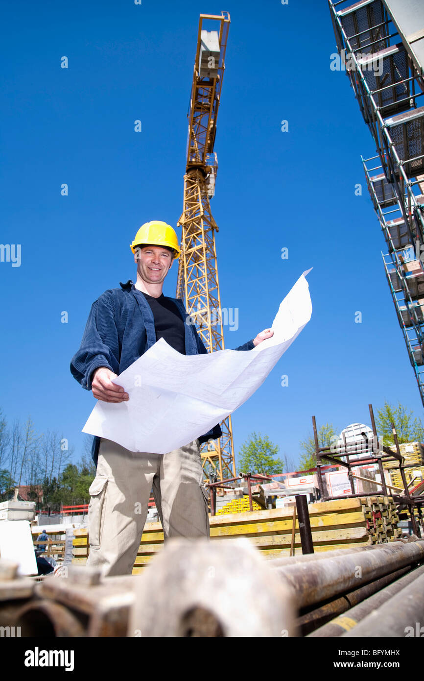 Architekt mit Blaupause auf Baustelle Stockfoto