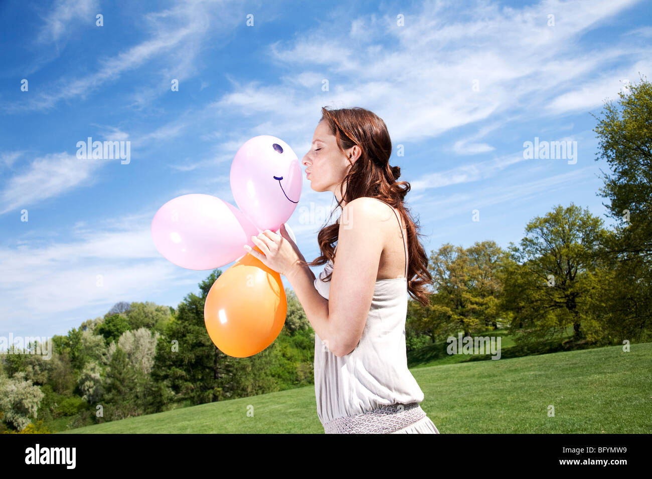 junge Frau im Park küssen Ballon Stockfoto