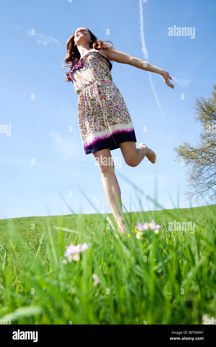 junge Frau läuft durch Rasen im park Stockfoto