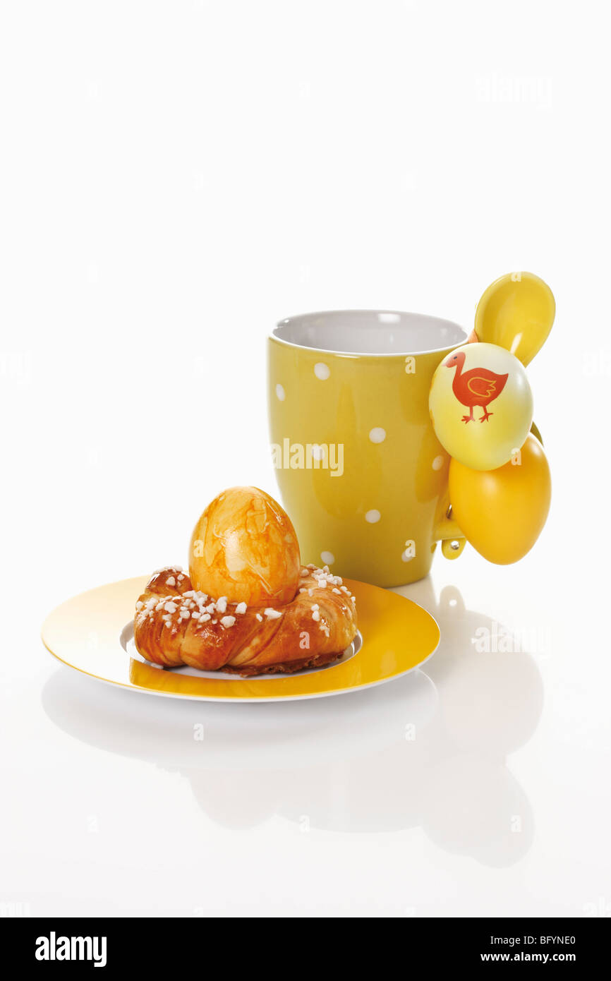 Kaffeebecher mit kleinen Savarin und Easter eggs Stockfoto