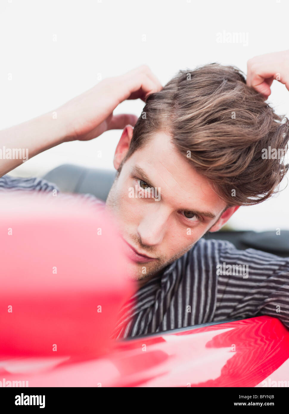 Mann sucht in Außenspiegel des Autos Stockfoto