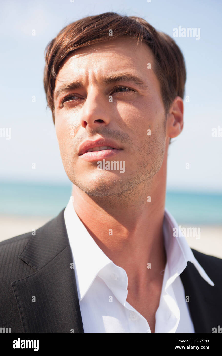 Bräutigam am Strand schaut sich um Stockfoto