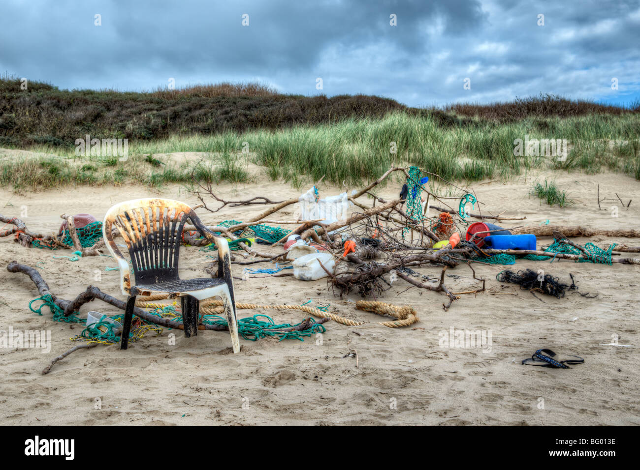 Mischung aus bunten Müll, Seile und Treibholz, die an einem Strand angespült wurde und gestapelt zusammen an Pembrey, Wales Stockfoto