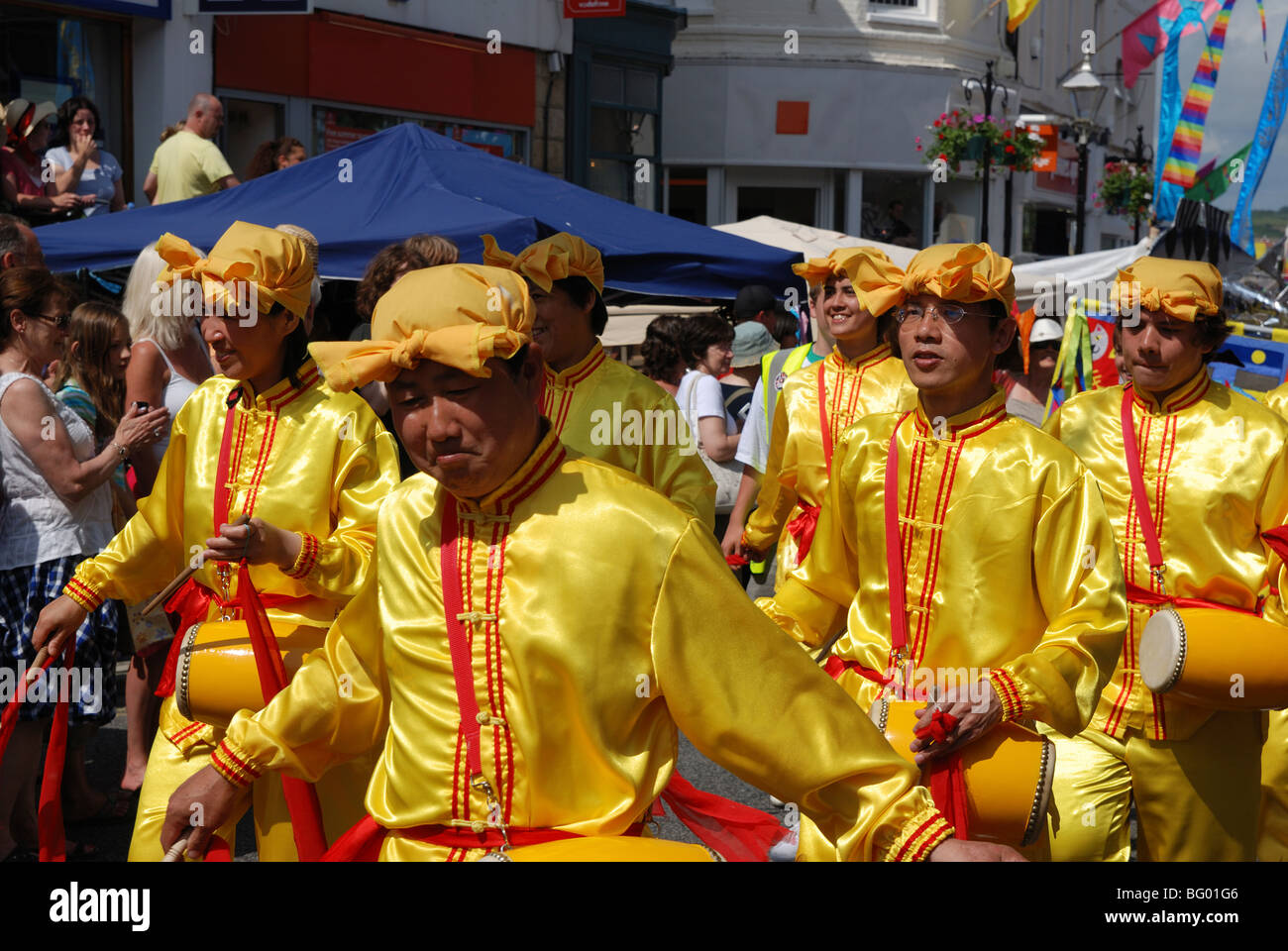 Mitglieder der alten chinesischen Kultur "Falun Gong" marschieren durch die Straßen von Penzance in Cornwall, Großbritannien Stockfoto