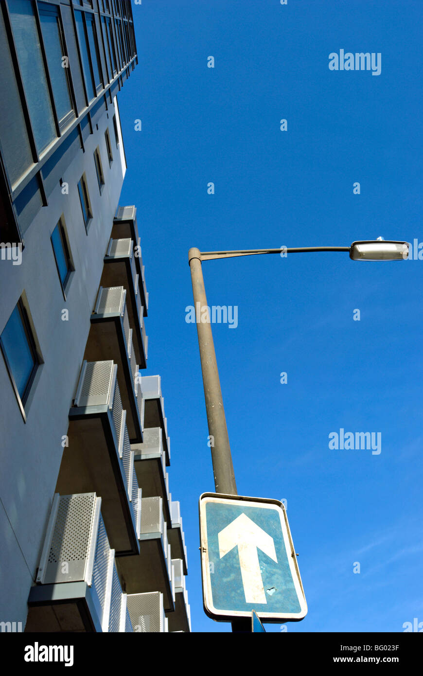 schmuddelig und misshandelte Einweg Zeichen gesehen gegen einen blauen Himmel und einem großen Wohnblock, in Wimbledon, London, england Stockfoto