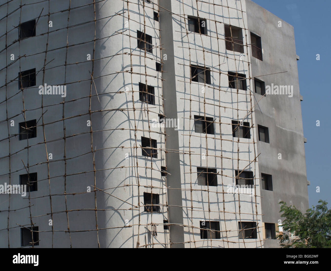 klapprigen Gerüsten auf Delhi Gebäude suchen, unregelmäßige und unsichere wirft kurvenreiche Schatten auf das Gesicht der unvollendeten Struktur Stockfoto