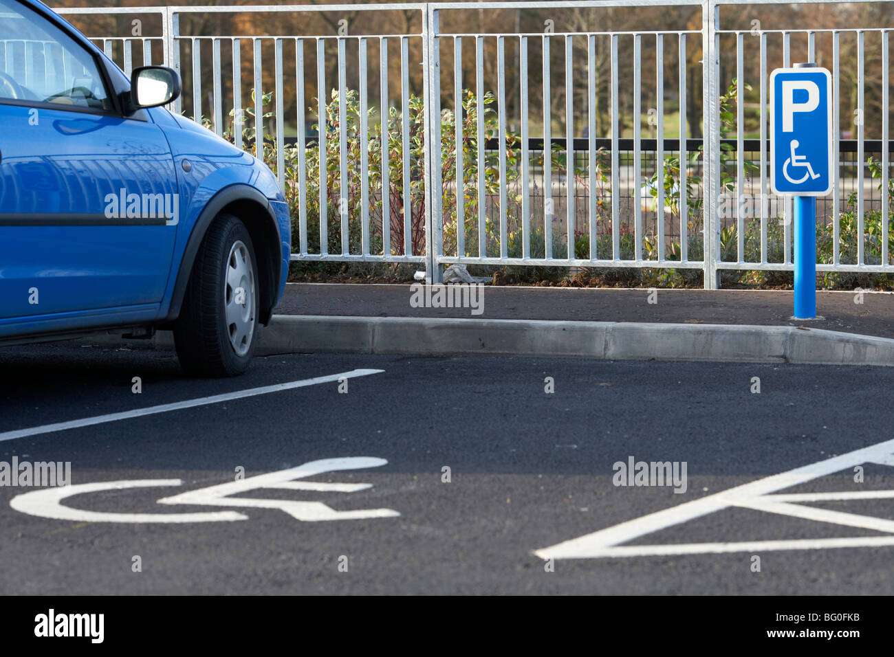 Post mit behinderten Parkplatz Schild vor ein Stellplatz auf einem Parkplatz in der Großbritannien-Irland Stockfoto