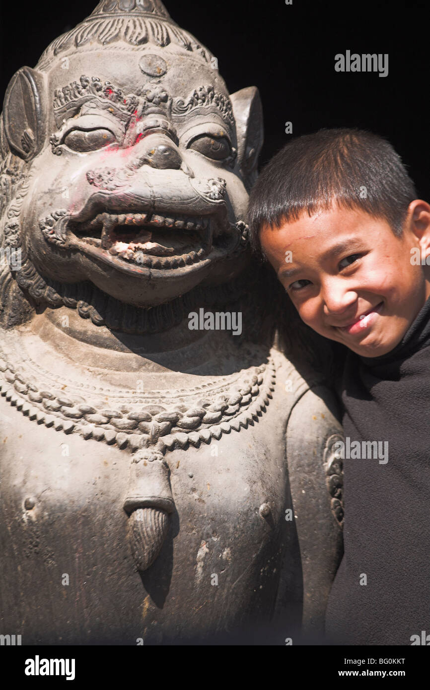 Junge steht von Statue, Hanuman Dhoka Durbar Square, UNESCO-Weltkulturerbe, Kathmandu, Nepal, Asien Stockfoto