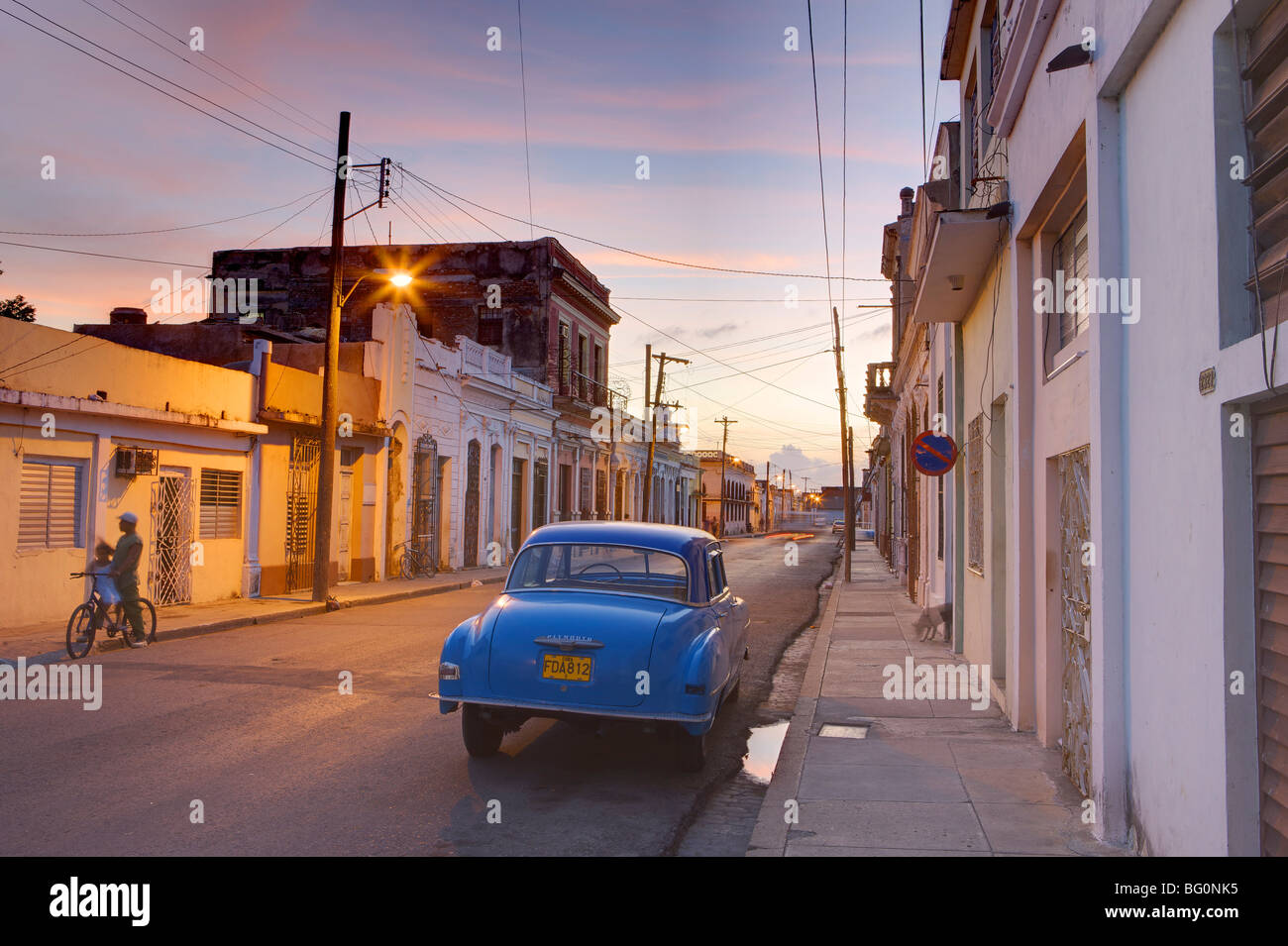 Straßenszene in der Dämmerung mit blauen amerikanische Oldtimer, Cienfuegos, Kuba, Karibik, Mittelamerika Stockfoto