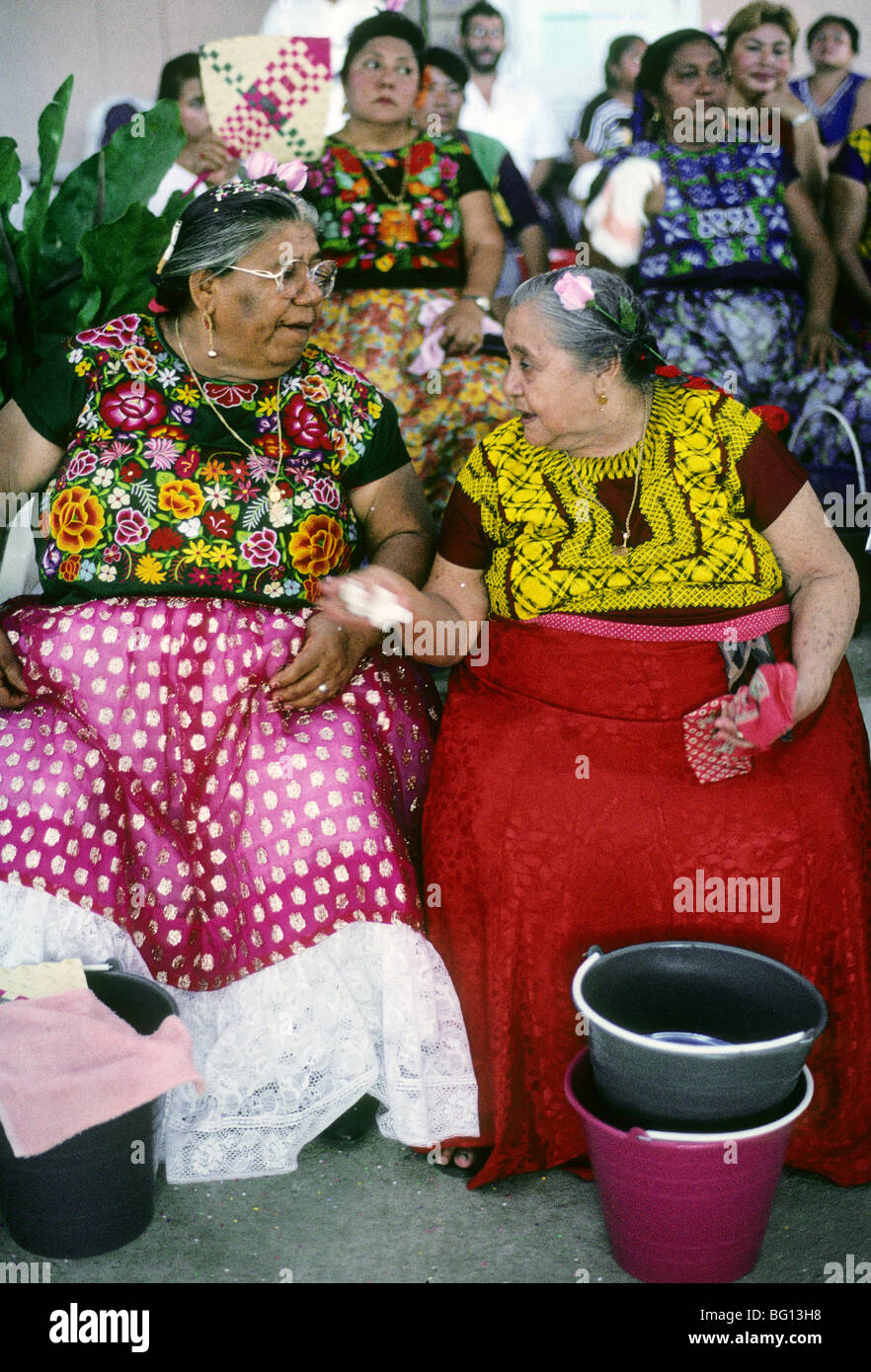 Zwei Frauen in Fiesta Kleidung gekleidet haben ein Gespräch in Tehuantepec, Mexiko Stockfoto