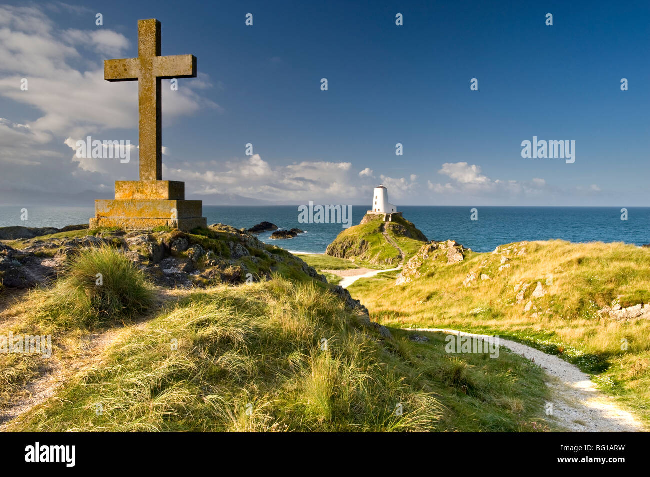Stone Cross und Twr Mawr Lighthouse auf Llanddwyn Island, in der Nähe von Newborough, Anglesey, North Wales, Großbritannien Stockfoto