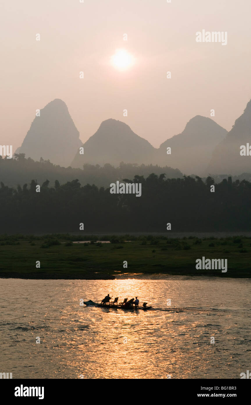 Touristenboot Segeln durch die Karst-Landschaft bei Sonnenaufgang auf dem Li-Fluss (Lijiang) in Yangshuo, nr Guilin, Provinz Guangxi, China Stockfoto