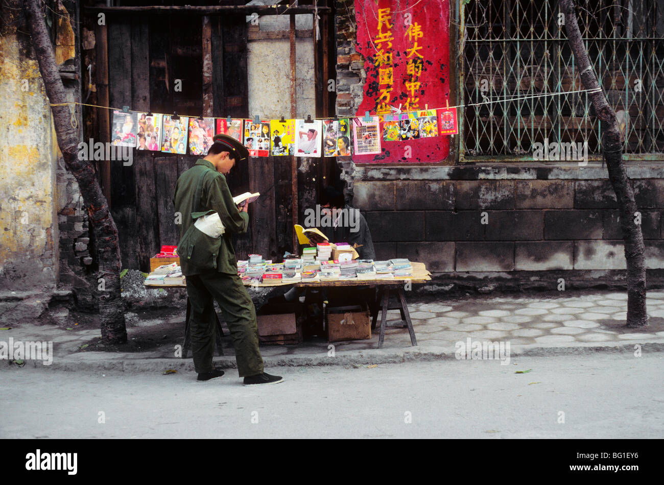 Ein Soldat liest ein Buch in einem Buch- und Zeitschriftenverlage Straße Stand in Dali, China Stockfoto