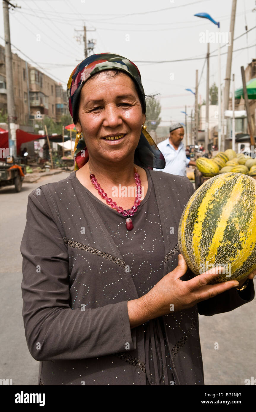 Eine Uyghur Frau mit dem berühmten Hami Melone. Stockfoto