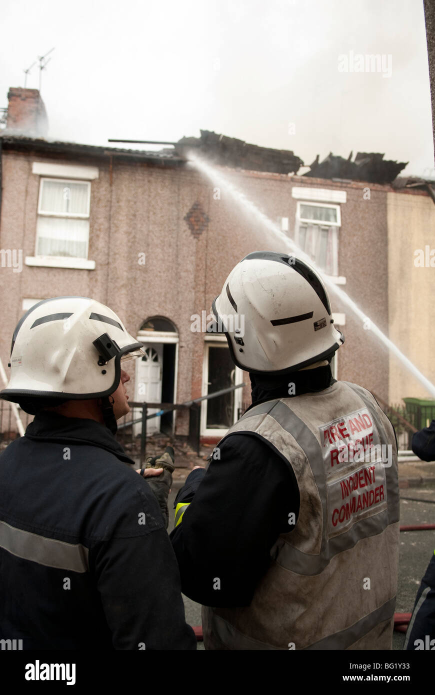 zwei Feuerwehrmänner Umfrage Schäden am Haus Brandgefahr durch Gasexplosion Stockfoto
