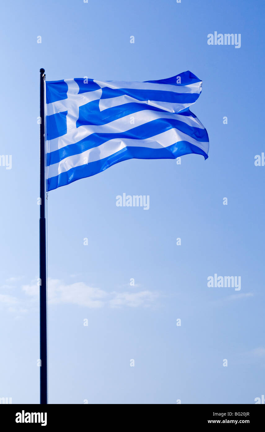 Griechische Flagge auf einem Mast mit blauem Himmel hinter Stockfoto