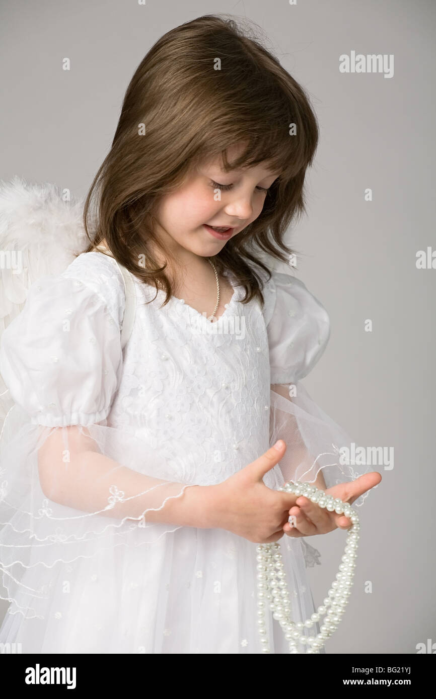 kleines Mädchen im weißen Kleid und Engel Flügel Stockfoto