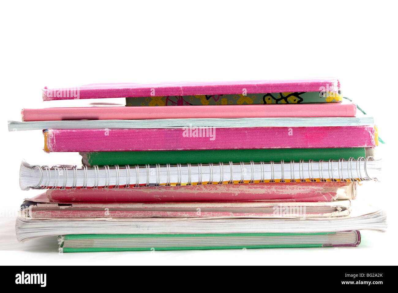 Haufen von Schulbüchern in rosa und grün Papier isoliert auf weißem Hintergrund Stockfoto