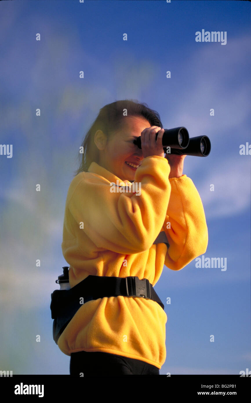 Asiatische Frau im Feld mit dem Fernglas Stockfoto