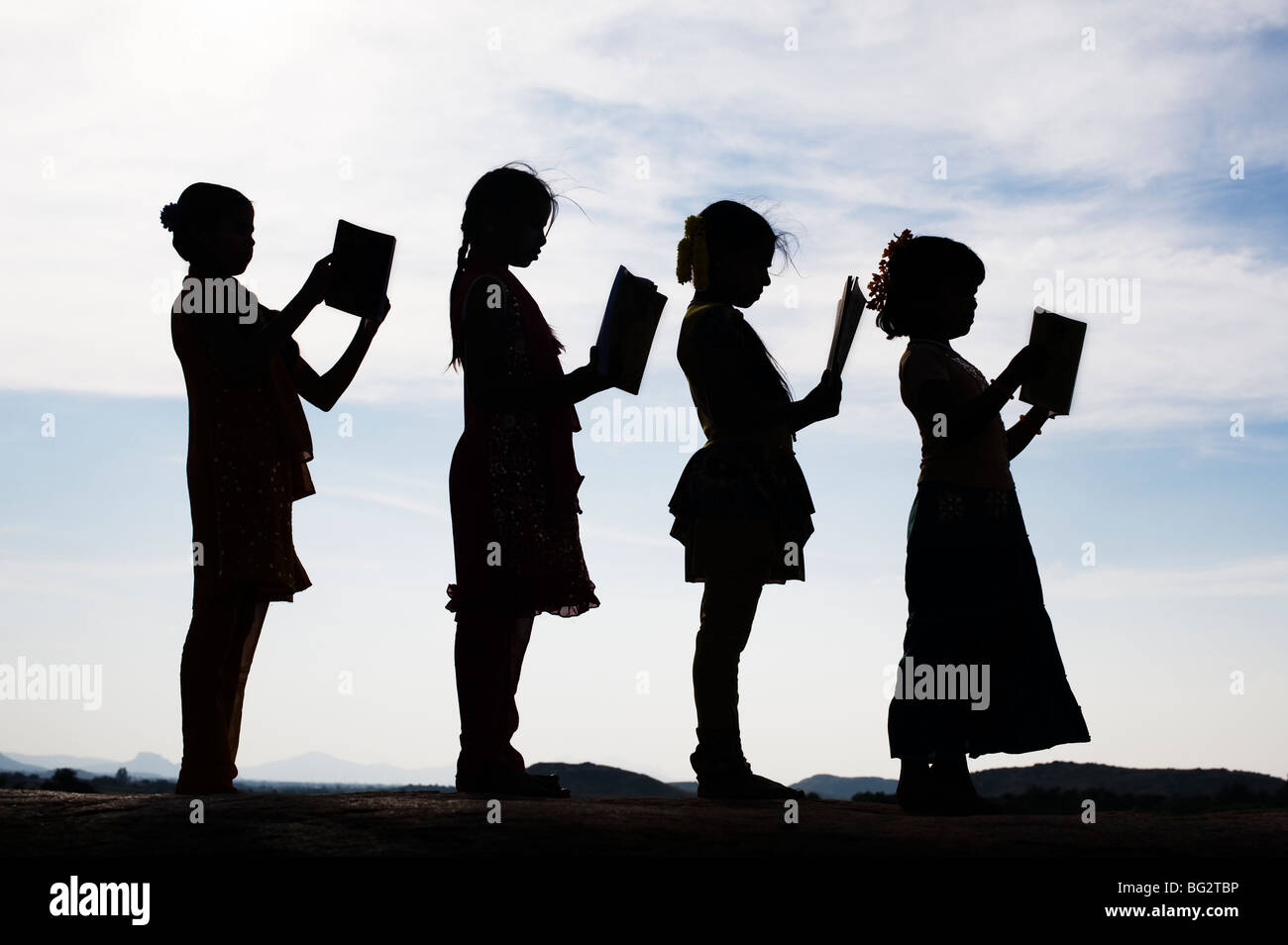 Silhouette eines indischen Mädchen lesen Bücher stehen in einer Linie Stockfoto