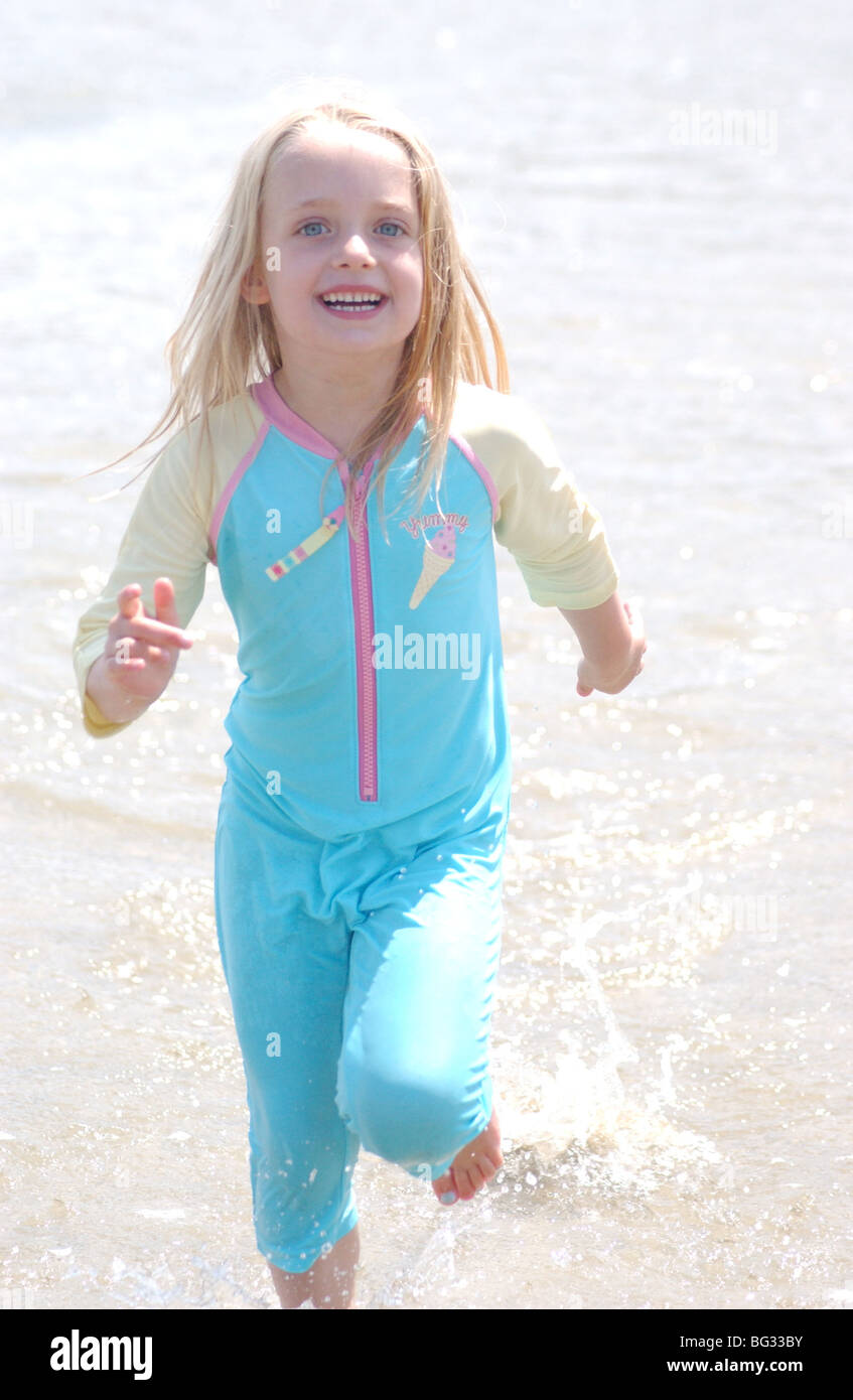Lizenzfreie kostenlose Foto von Mädchen laufen und lachend am Strand auf Familien-Sommerurlaub im Vereinigten Königreich Stockfoto