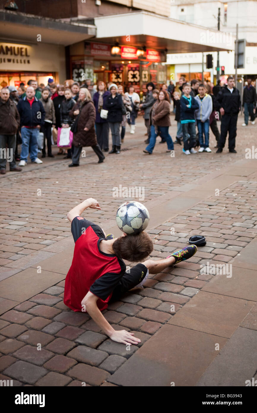 Großbritannien, England, Manchester, Market Street, Fußball jonglieren Busker Ausgleich Ball auf Kopf Stockfoto