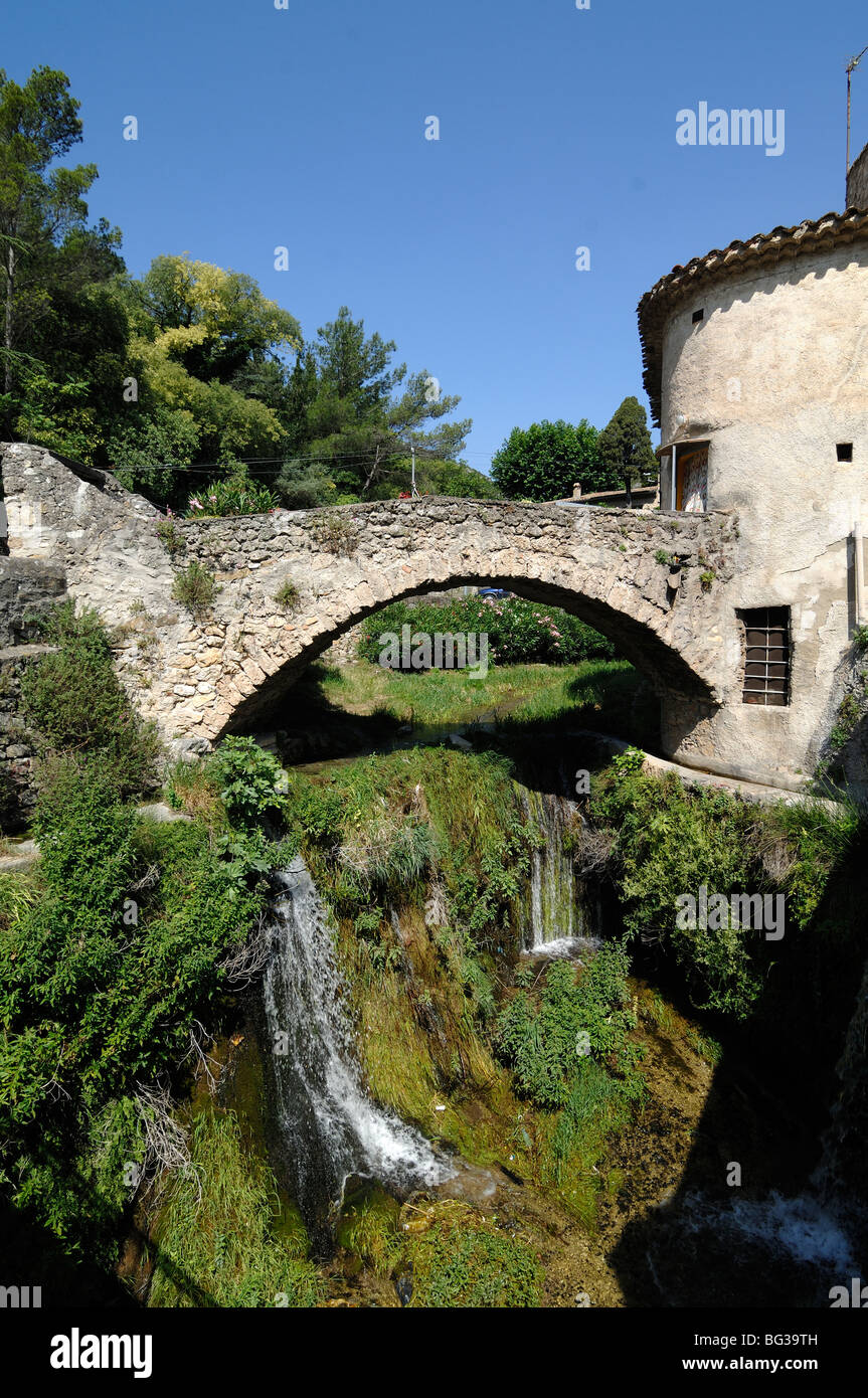 Alte Steinbrücke über den Fluss Verdus, Cascade oder Wasserfall & Dorfhaus, Saint Guilhem le Désert, Hérault, Languedoc Roussillon, Frankreich Stockfoto