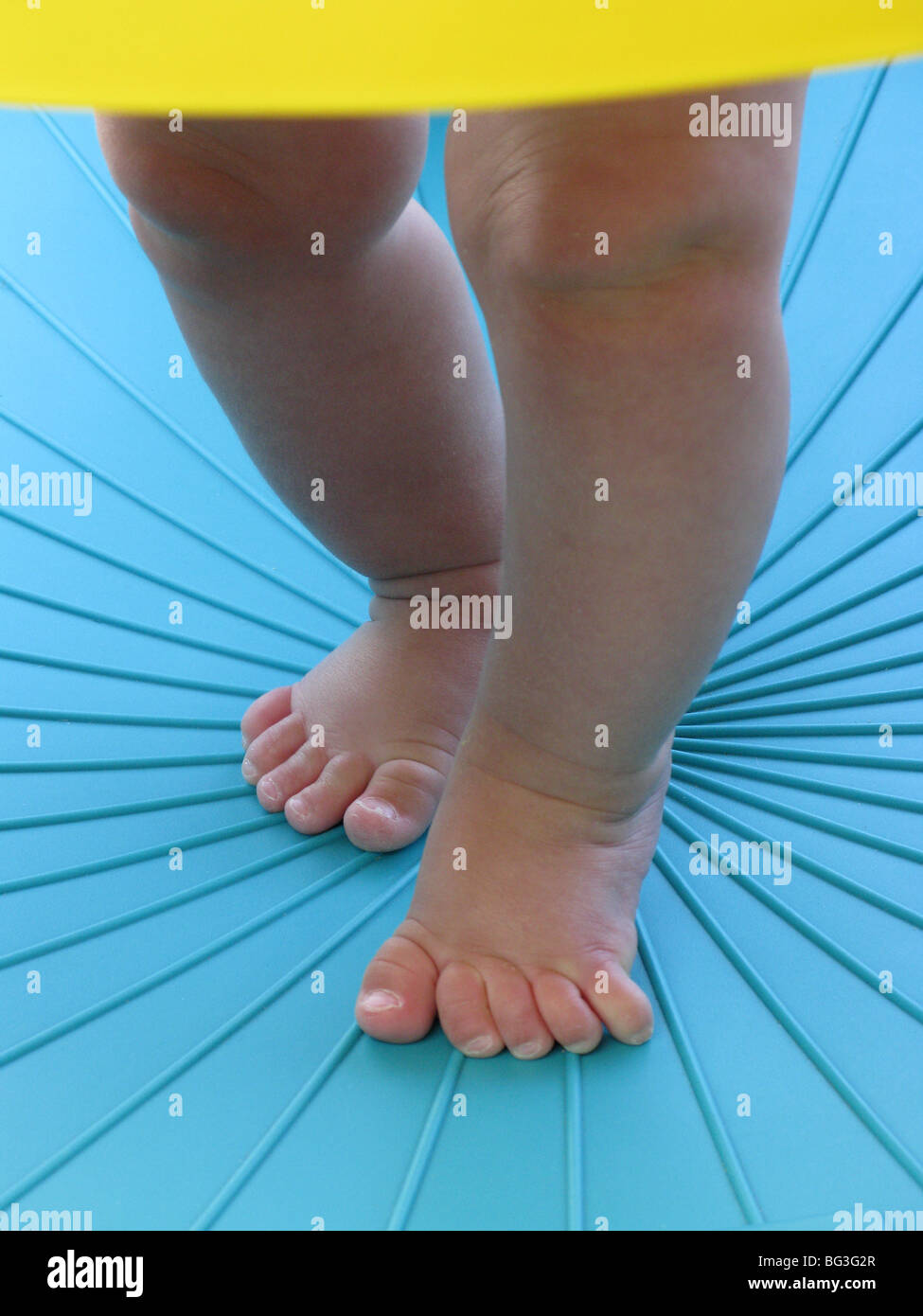 Beine und Füße eines Kindes in einer blauen Umgebung laufen lernen Stockfoto