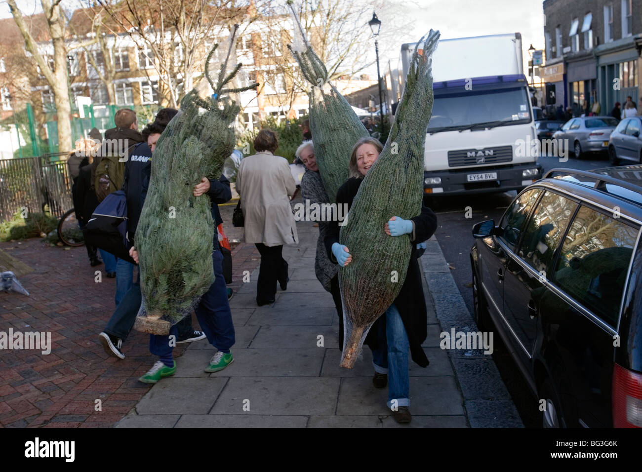 Menschen kaufen Weihnachtsbäume vom Columbia Road Blumenmarkt in Ost-london Stockfoto