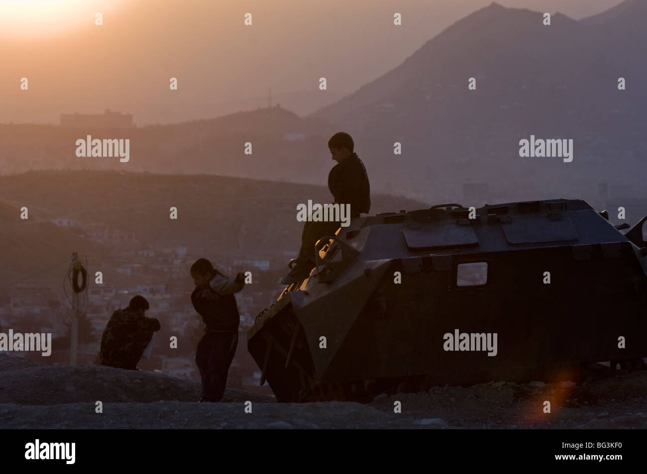 Afghanische Kinder spielen auf einem alten sowjetischen Bogen oberhalb der Stadt Kabul, Afghanistan. Stockfoto