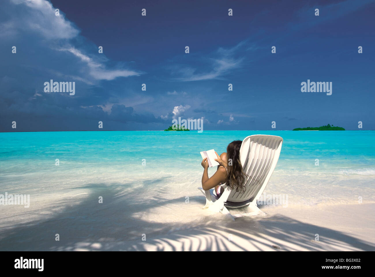 Frau liest ein Buch am Strand, Malediven, Indischer Ozean, Asien Stockfoto