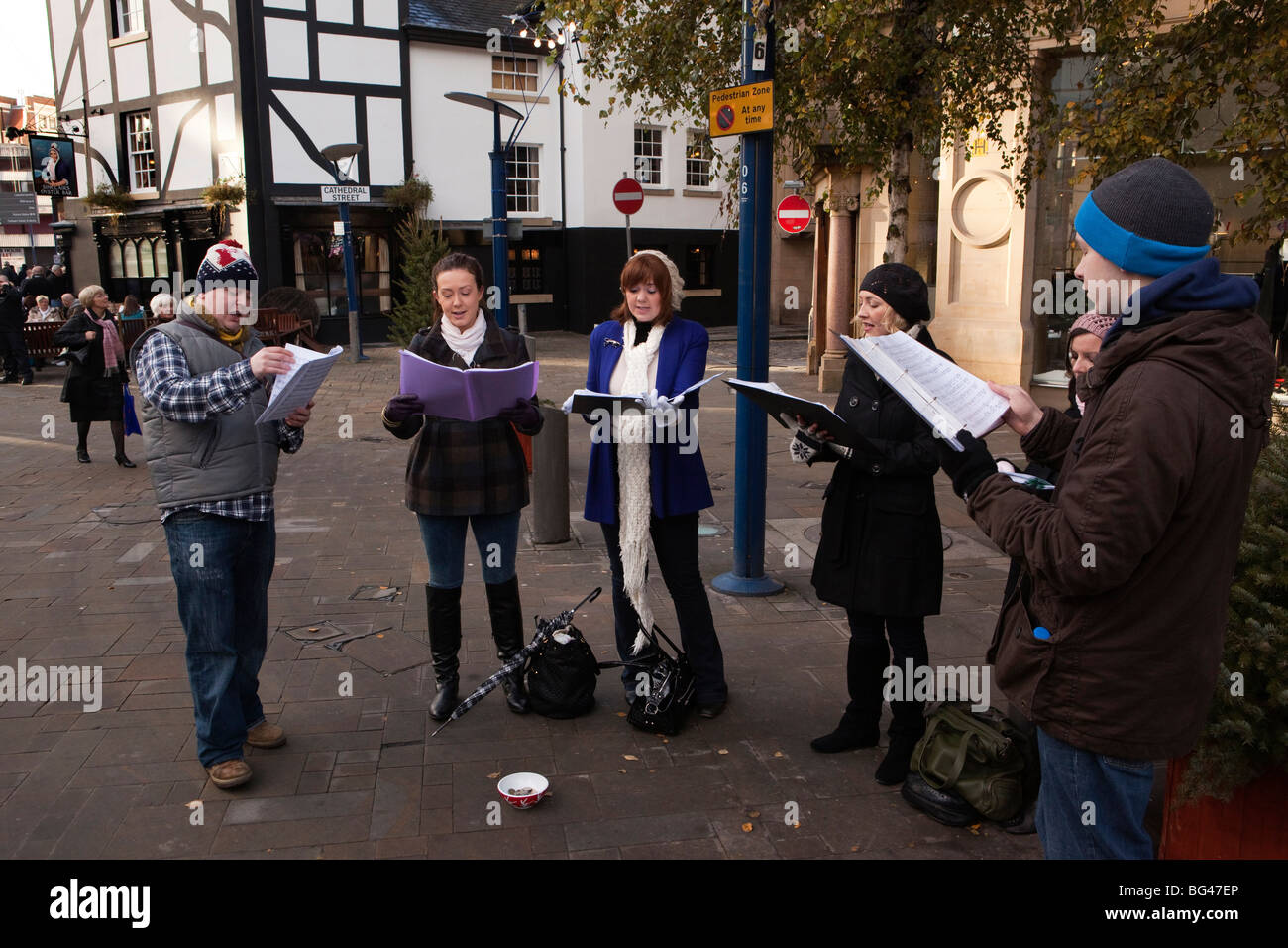 Großbritannien, England, Manchester, Cathedral Street, Voce Scura junger Menschen Chor Mitglieder Carol singen Stockfoto