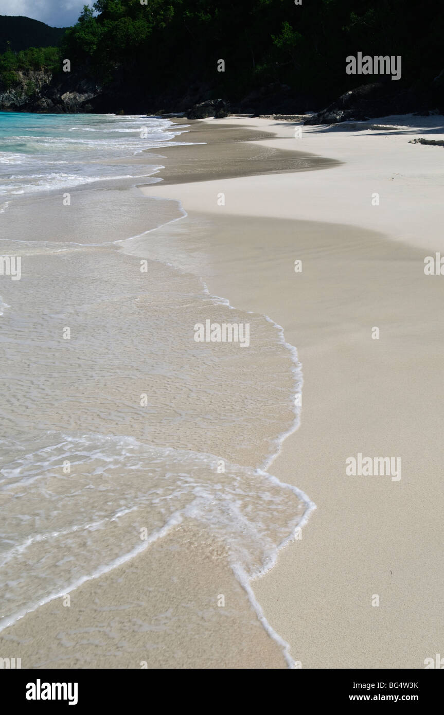 Cinnamon Bay Beach St John US Virgin Islands // CINNAMON BAY, US Virgin Islands – Ein malerischer Blick auf Cinnamon Bay, einen unberührten tropischen Strand am Nordufer von St. John auf den US Virgin Islands. Der halbmondförmige Strand mit seinem weißen Sand und türkisfarbenem Wasser ist von üppiger Vegetation umgeben, was die natürliche Schönheit der Karibik veranschaulicht. Stockfoto