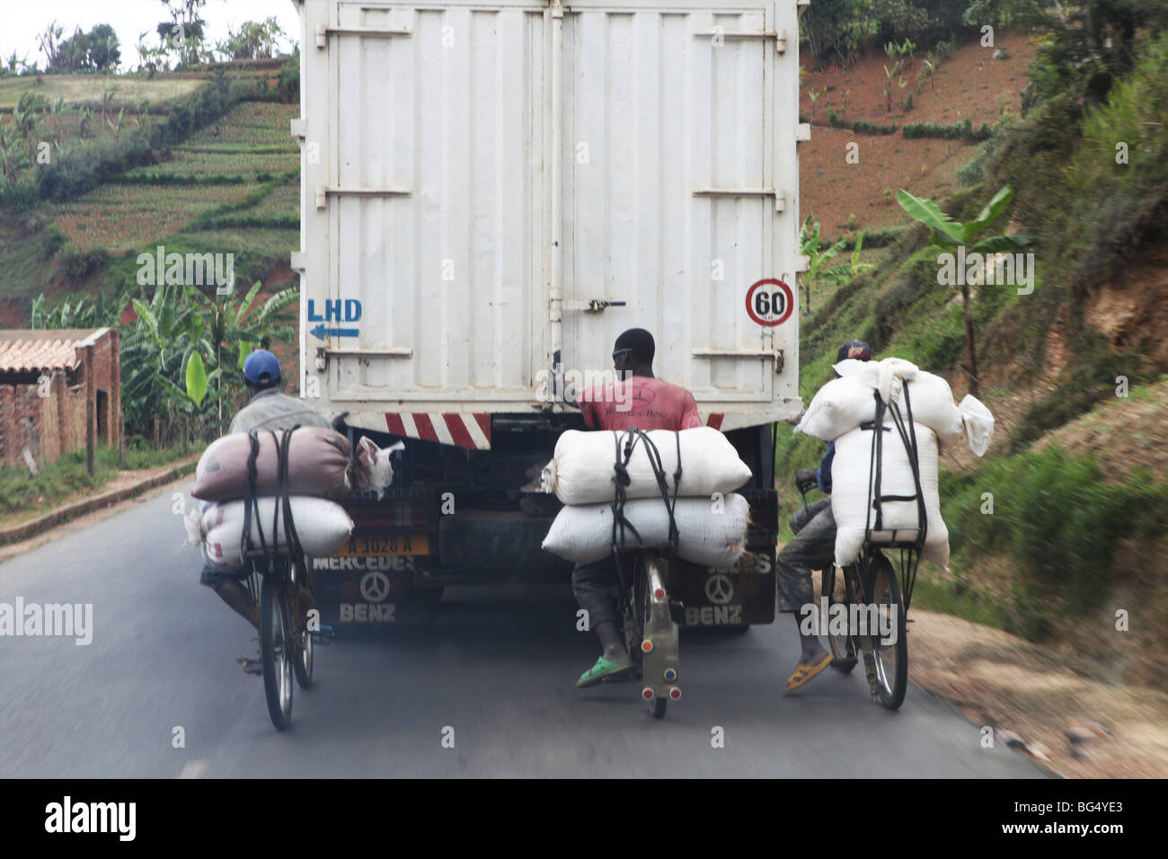 Young burundische halten sich auf einen LKW auf den hügeligen Straßen in Burundi Stockfoto