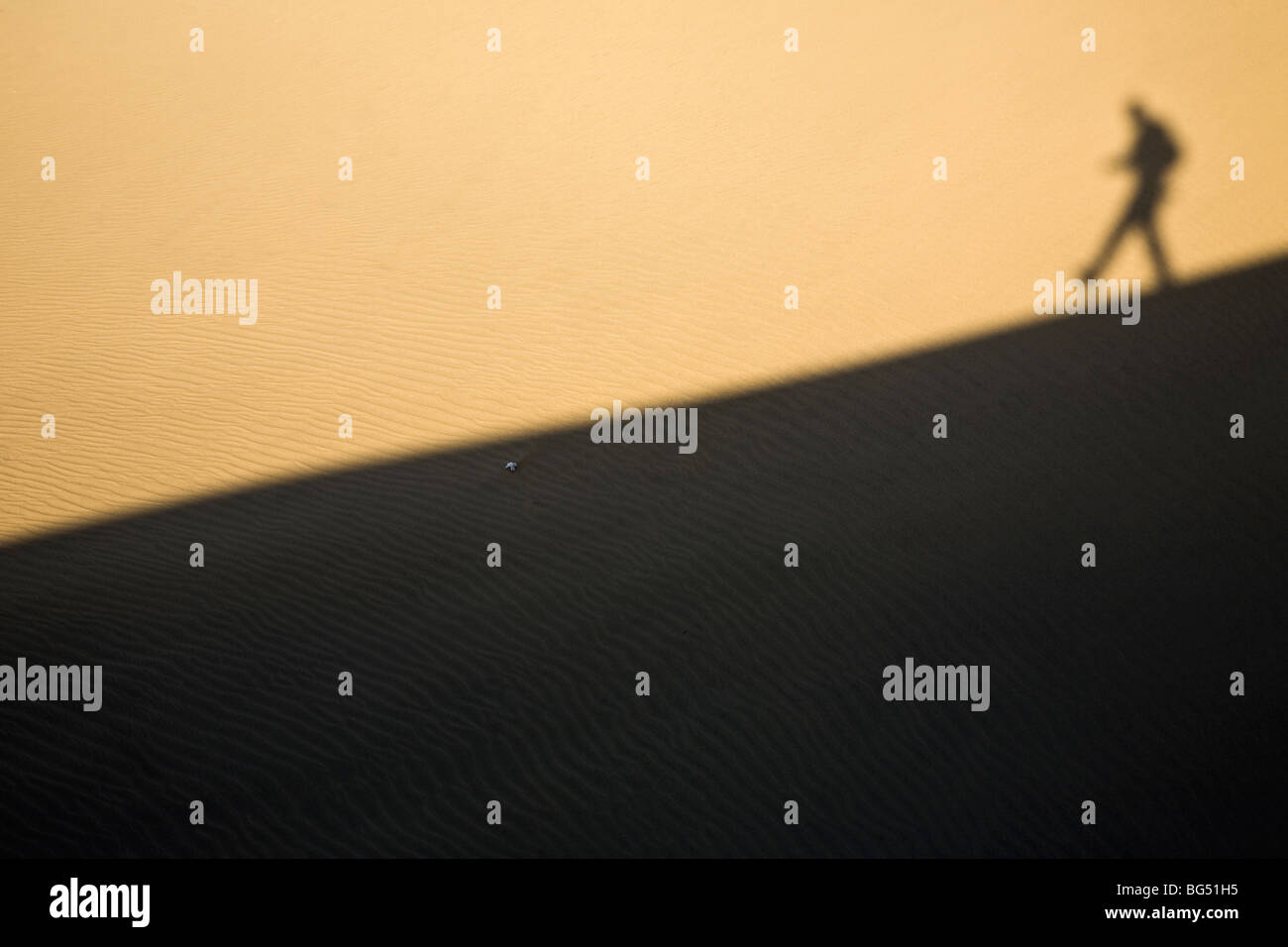 Schatten eines Mannes hinunter eine Sanddüne Stockfoto