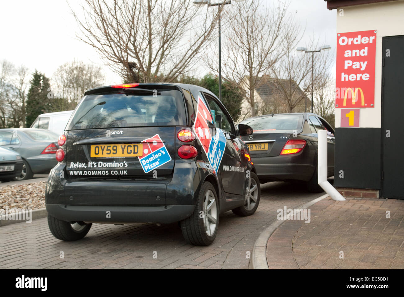 Dominos Pizza Smart Auto in der Warteschlange ein McDonalds drive thru Stockfoto
