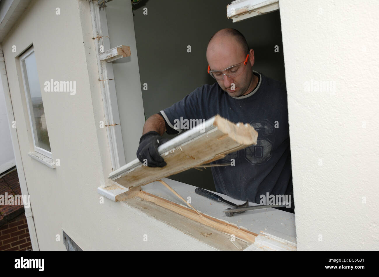 Entfernen alte Fensterrahmen vor Installation neue doppelt verglaste Fenster in einem Haus Stockfoto