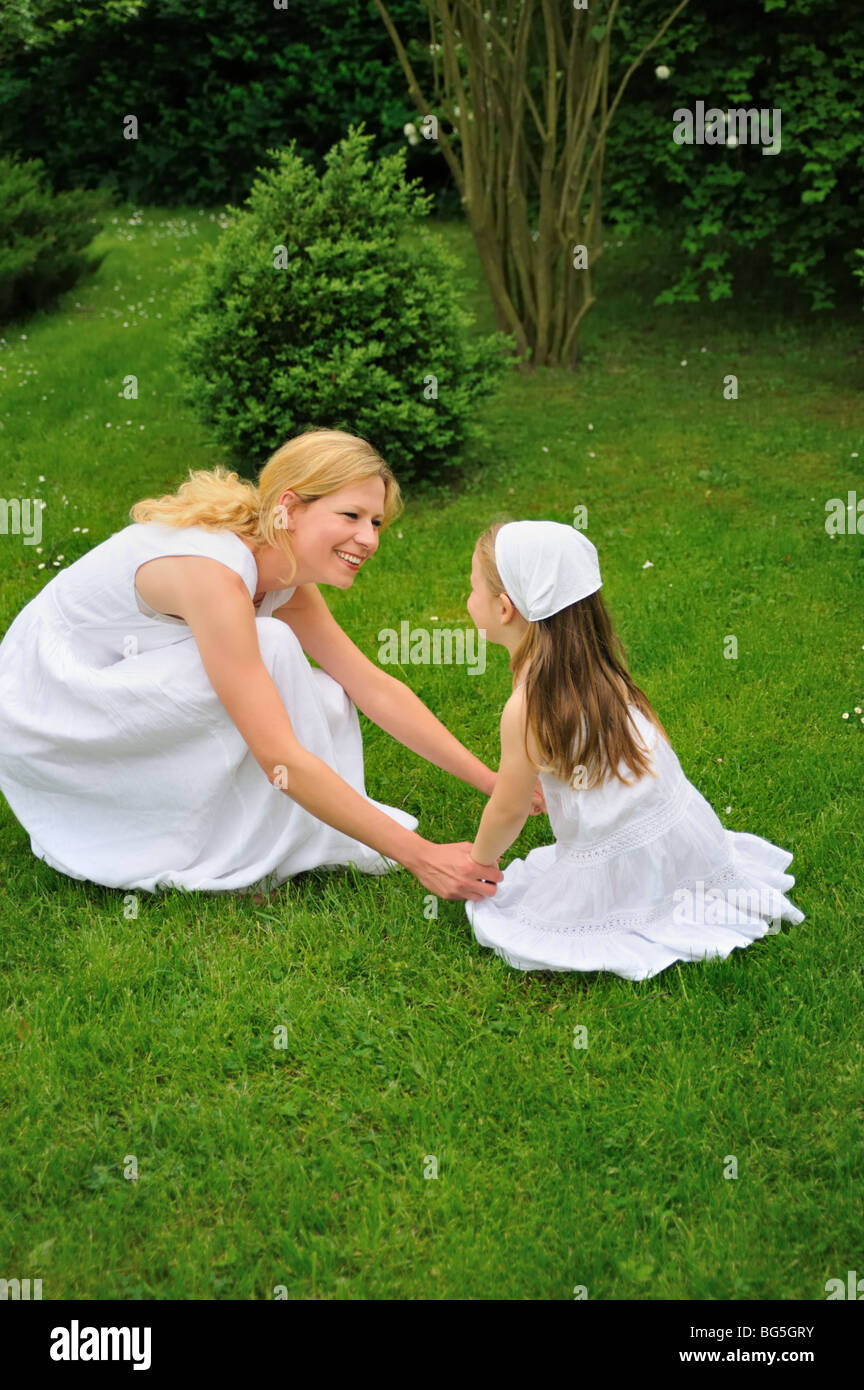 Junge Mutter und Tochter spielen in Wiese Stockfoto