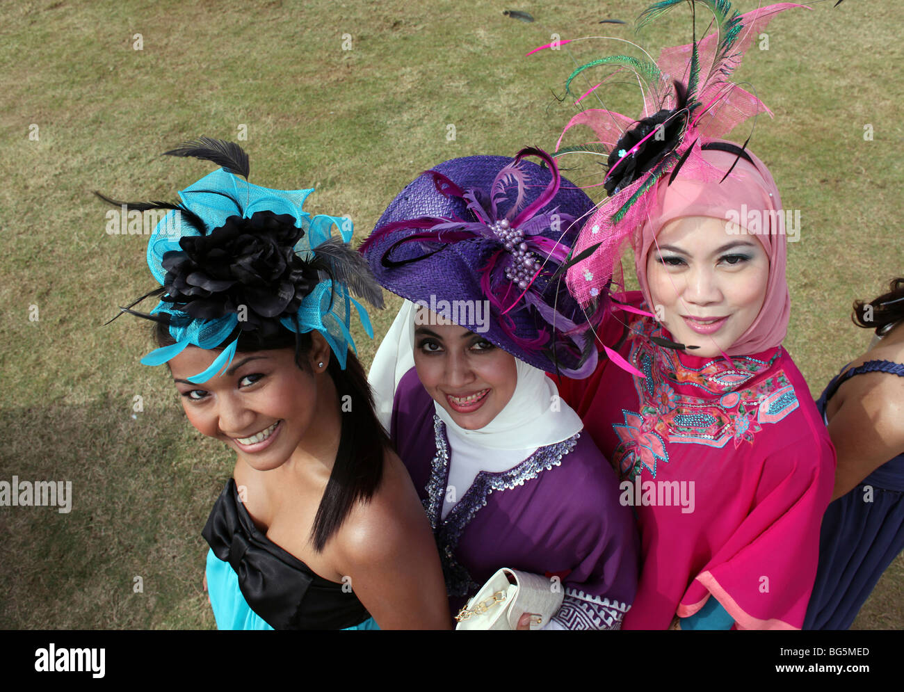Elegant gekleidete Frauen Hüte zu tragen, während ein Pferderennen, Dubai, Vereinigte Arabische Emirate Stockfoto