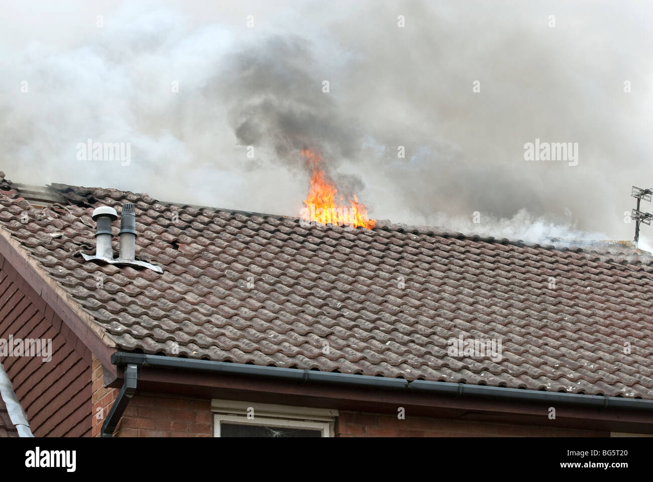 Hausdach auf Feuer mit Flammen Ausgabe Stockfoto