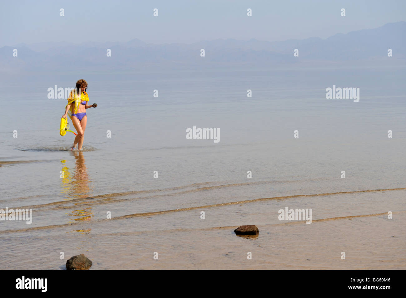 Frau im Bikini zu Fuß aus Meer mit dunstige Atmosphäre Stockfoto