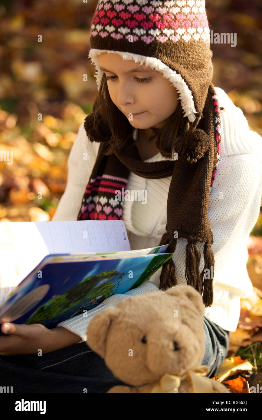 Junges Mädchen studieren außerhalb nach Schule Stunde mit ihr Teddy Bär Stockfoto