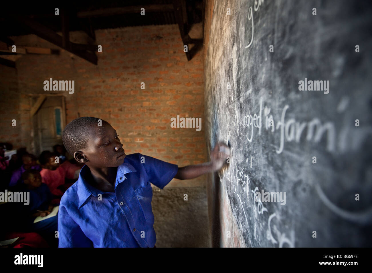 Eine Mädchen schreibt auf einer Tafel im Klassenzimmer in Amuria, Uganda. Stockfoto