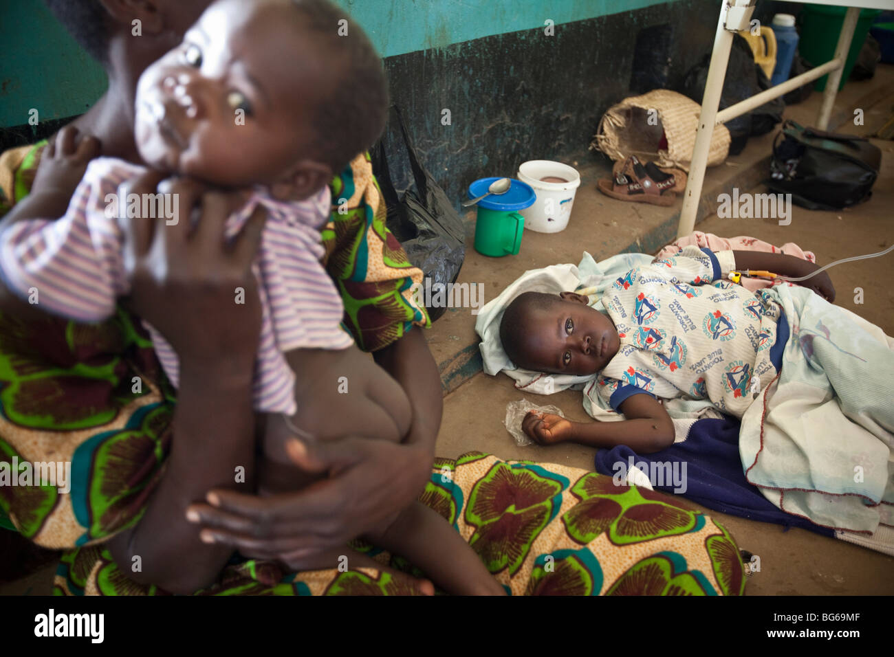 Ein Kind an Malaria liegt auf dem Boden eines Krankenhauses in Amuria, Uganda. Stockfoto