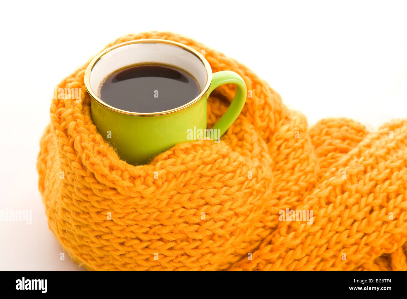 Grüne Becher eingewickelt gelbes Tuch auf weißem Hintergrund Stockfoto