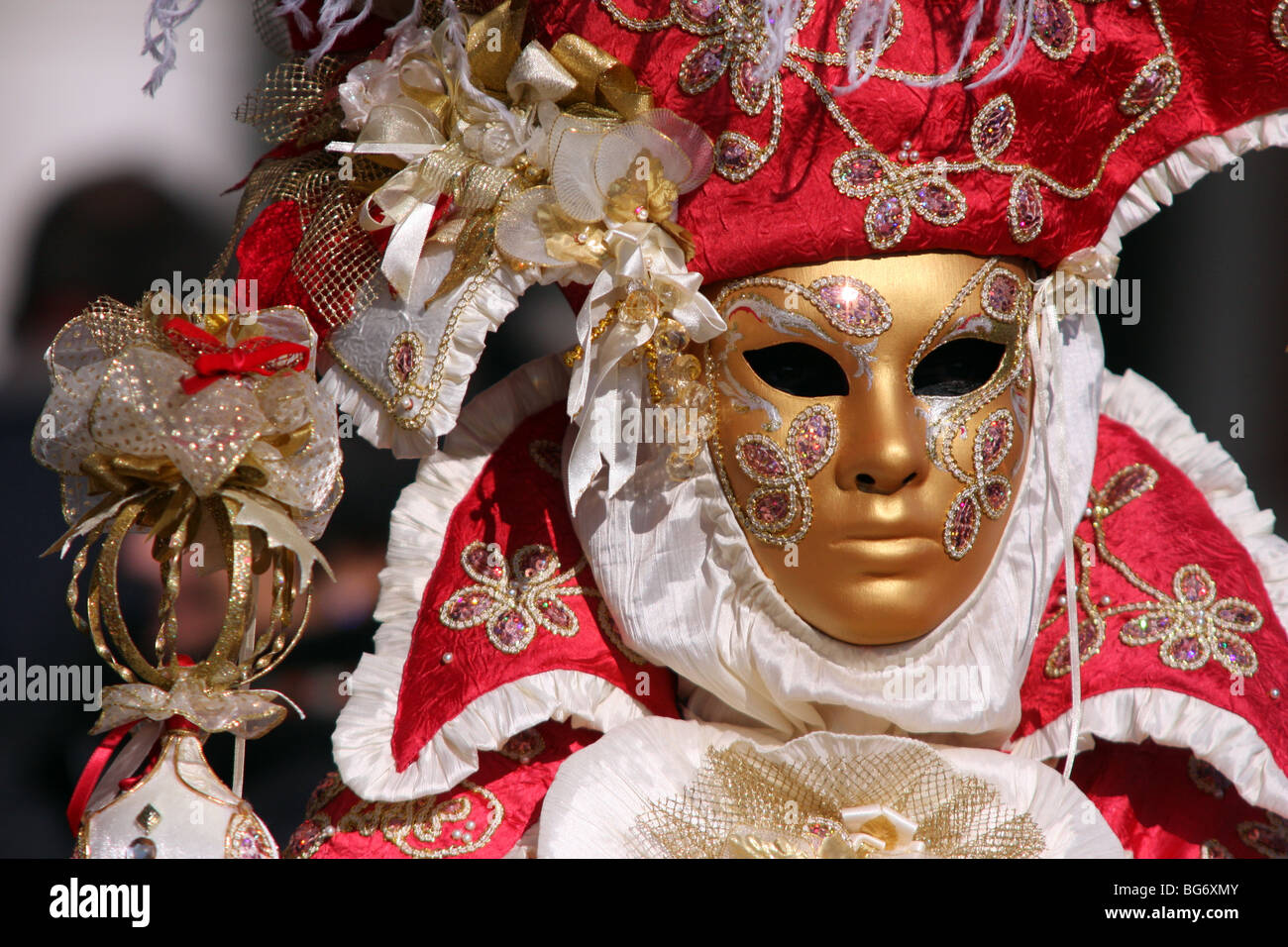 Nahaufnahme eines venezianischen Mann oder Frau trägt eine goldene Maske und einem roten und weißen bestickten Kostüm in Venedig Karneval 2009 Stockfoto
